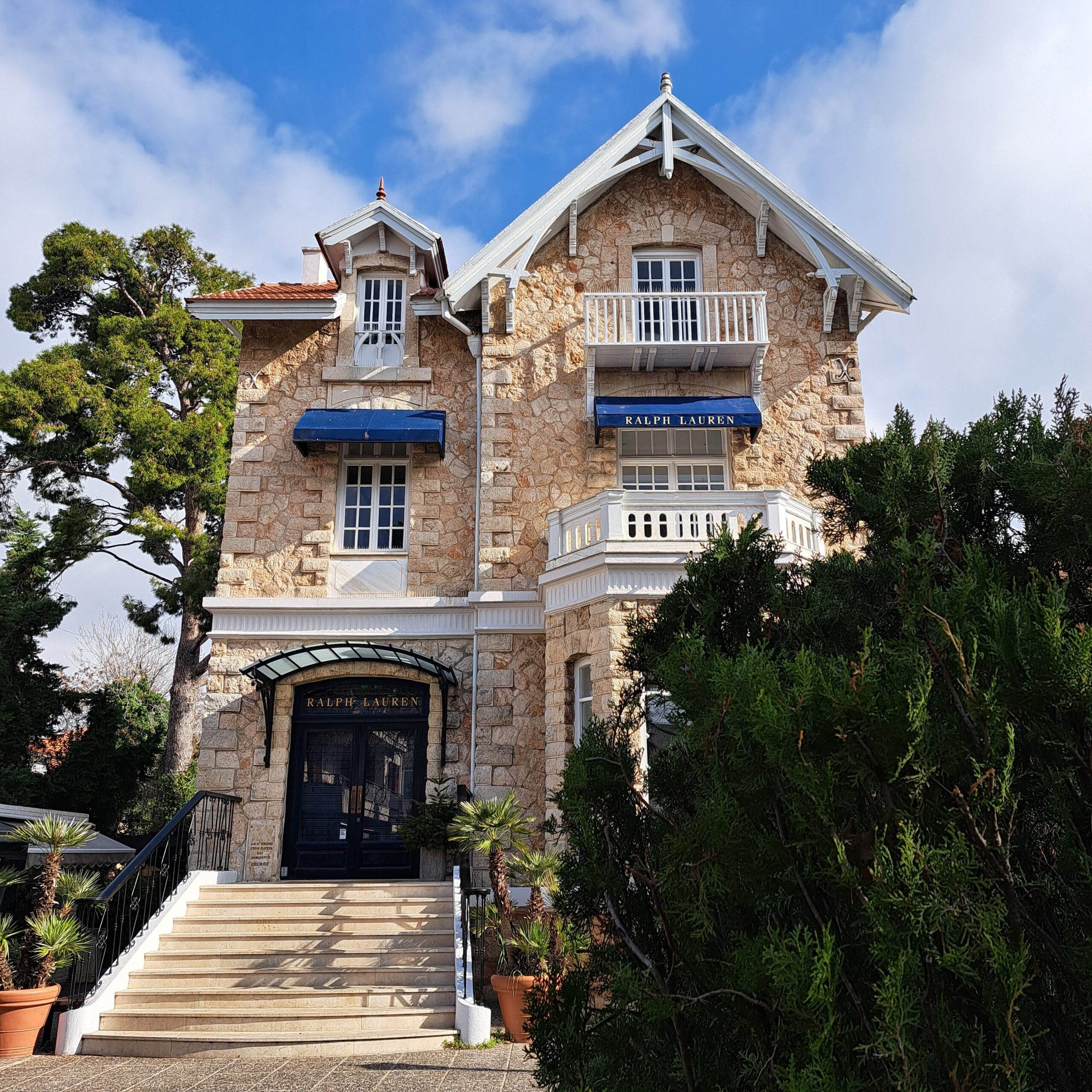 Exterior of a classic stone building featuring Ralph Lauren signage under blue sky.